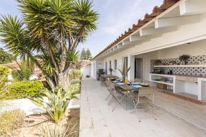 un patio esterno con tavolo e palma di Estoril Contemporary Garden Villa by CadenzaLux a Cascais