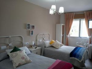 sypialnia z dwoma łóżkami i oknem w obiekcie CASA DA MADRIÑA w mieście Cambados