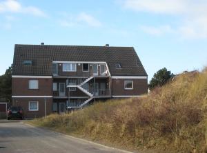 een gebouw aan de zijkant van een heuvel bij 2 min zum Strand in Borkum