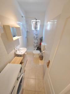 a white bathroom with a sink and a toilet at Apartment Zvonko in Stara Novalja