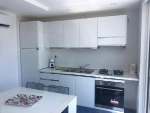 a white kitchen with a sink and a stove at suite scauri-inn in Scauri