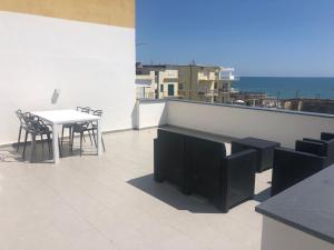 a balcony with a table and chairs and the ocean at suite scauri-inn in Scauri
