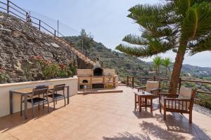 een patio met een tafel en stoelen en een grill bij La Casita de mama in Vélez-Málaga