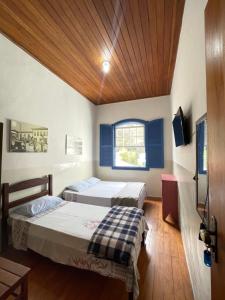 una camera con due letti e una tv di Hostel Central a Ouro Preto