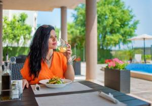 a woman sitting at a table with a plate of food at Royal Marina Beach in Chernomorets +84 photos