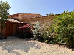 una casa de ladrillo con una puerta y algunos arbustos en Maison à Gordes dans le Lubéron, en Gordes