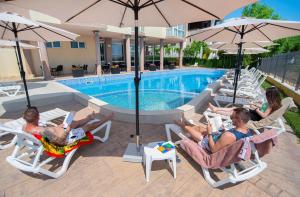 a group of people sitting in lawn chairs by a pool at Royal Marina Beach in Chernomorets