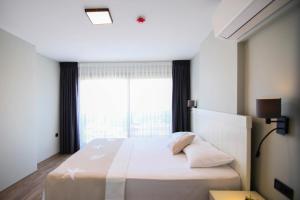 a bedroom with a large bed with a large window at Krem Marin Otel in Cesme