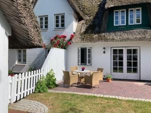 un patio con mesa y sillas frente a una casa en Villa Deichhof en Dunsum