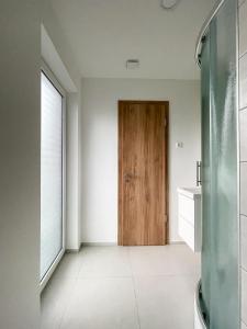 a bathroom with a wooden door and a sink at Rooms Minka in Kamna Gorica