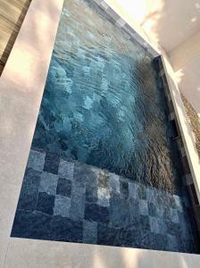 una piscina con suelo de mosaico en una habitación en Maison à Gordes dans le Lubéron, en Gordes