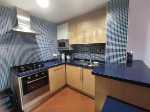 una pequeña cocina con azulejos azules en las paredes en 3H Terrace - Casas & Papéis, en Armação de Pêra