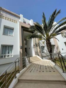 schody z palmą przed budynkiem w obiekcie Andalucia Bizerte plage et piscine w mieście Bizerta