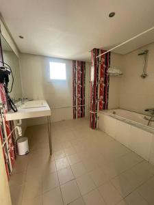 ein Badezimmer mit einem Waschbecken und einer Badewanne in der Unterkunft Andalucia Bizerte plage et piscine in Bizerte