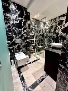 Majorelle Splendide Appartement في مراكش: حمام اسود وبيض مع مرحاض ومغسلة