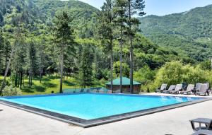 a large swimming pool with chairs and a gazebo at Vila Sunce Village Resort Konjic in Konjic