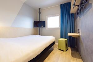 a hotel room with a bed and a tv at ibis Budget Villemomble in Villemomble