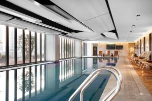 een zwembad in een gebouw met ramen bij Wyndham Garden Shenzhen Longhua in Shenzhen