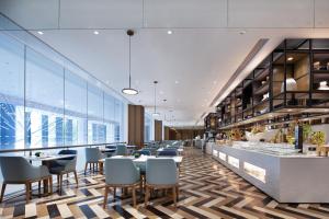 een restaurant met tafels en stoelen en een bar bij Wyndham Garden Shenzhen Longhua in Shenzhen