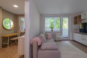 ein Wohnzimmer mit einem Sofa und einem Tisch in der Unterkunft Convenient apartment with balcony by Polo Apartments in Kaunas