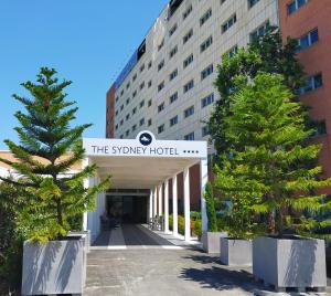a hotel with two trees in front of a building at The Sydney Hotel in Bologna