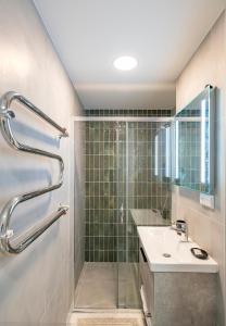 y baño con ducha y lavamanos. en Convenient apartment with balcony by Polo Apartments, en Kaunas