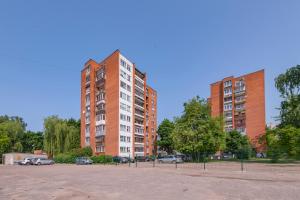 dos edificios altos de ladrillo rojo en un estacionamiento en Convenient apartment with balcony by Polo Apartments, en Kaunas