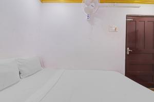 a bedroom with a white bed and a brown cabinet at Guest Inn Near Hyderabad Central in Hyderabad