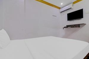 a white room with a bed and a tv on a wall at Guest Inn Near Hyderabad Central in Hyderabad