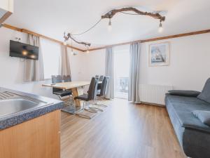 a kitchen and living room with a table and a couch at Apartment Bauernhof Birkhöfl by we rent in Zell am See