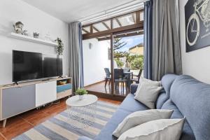 a living room with a blue couch and a tv at Holyhome mills 1113 in Costa Teguise