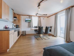 a kitchen and living room with a table and chairs at Apartment Bauernhof Birkhöfl by we rent in Zell am See