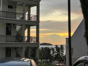 un edificio con vista sull'oceano al tramonto di The Corus Suites Port Dickson By MAISON a Port Dickson