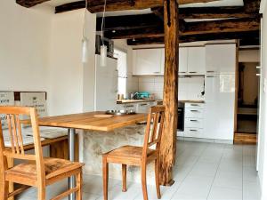 uma cozinha com uma mesa de madeira e 2 cadeiras em Ferienwohnung Die Schmiede em Schopfloch