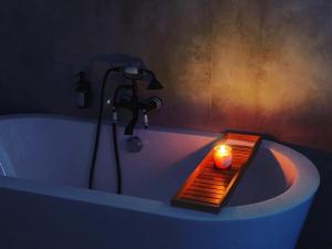 a bathroom with a bath tub with a candle in it at Maciejowiec Castle Hill Apartment I in Maciejowiec