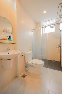 y baño con aseo, lavabo y ducha. en Light House Phú Quốc en Phu Quoc