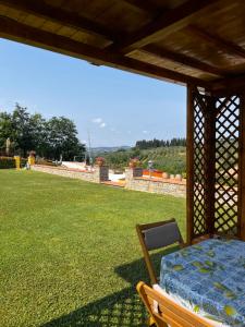 a wooden gazebo with a bed on a lawn at Colle Del Sole in Lastra a Signa