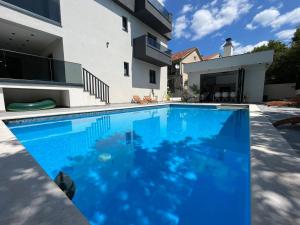 una grande piscina blu di fronte a una casa di Villa MS026, Imotski - Makarska a Poljica