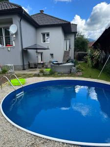 una piscina azul frente a una casa en Family Apartments Myto pod Dumbierom, en Mýto pod Ďumbierom