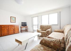 ein Wohnzimmer mit einem Sofa und einem Couchtisch in der Unterkunft Apartamento Vistas Vilar in Sanxenxo