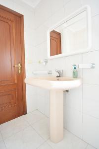 ein Badezimmer mit einem weißen Waschbecken und einem Spiegel in der Unterkunft Apartamento Vistas Vilar in Sanxenxo
