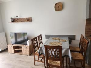 a dining room with a table and chairs and a tv at Dwa Jelonki, ul Ściegiennego, centrum, garaż, ogródek in Kielce