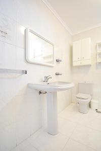 ein weißes Bad mit einem Waschbecken und einem WC in der Unterkunft Apartamento Vistas Vilar in Sanxenxo