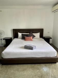 a bedroom with a large bed with two pillows at Spacious Apartment by the Sea in Bang Rak Beach
