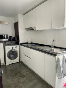 a kitchen with a sink and a washing machine at Spacious Apartment by the Sea in Bang Rak Beach