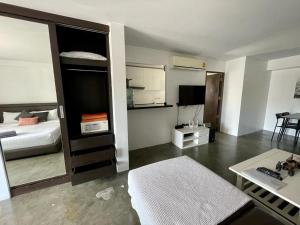 a living room with a bed and a room with a table at Spacious Apartment by the Sea in Bang Rak Beach