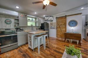 a kitchen with wooden floors and a ceiling fan at Blue Bungalow Lake Hamilton in Hot Springs