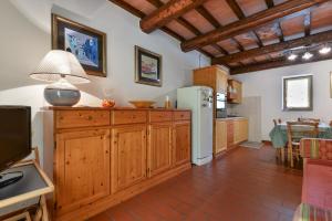 uma cozinha com armários de madeira e um frigorífico branco em Vacanzainmaremma - TG12 - Monte Amiata relax e tranquillità - Free parking em Castel del Piano
