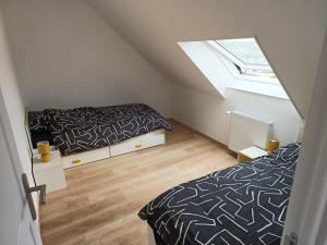 1 dormitorio en el ático con 2 camas y ventana en Appartement lumineux avec terrasse !, en Plonéour-Lanvern