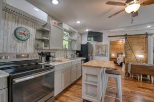a kitchen with white cabinets and a ceiling fan at Blue Bungalow Lake Hamilton in Hot Springs